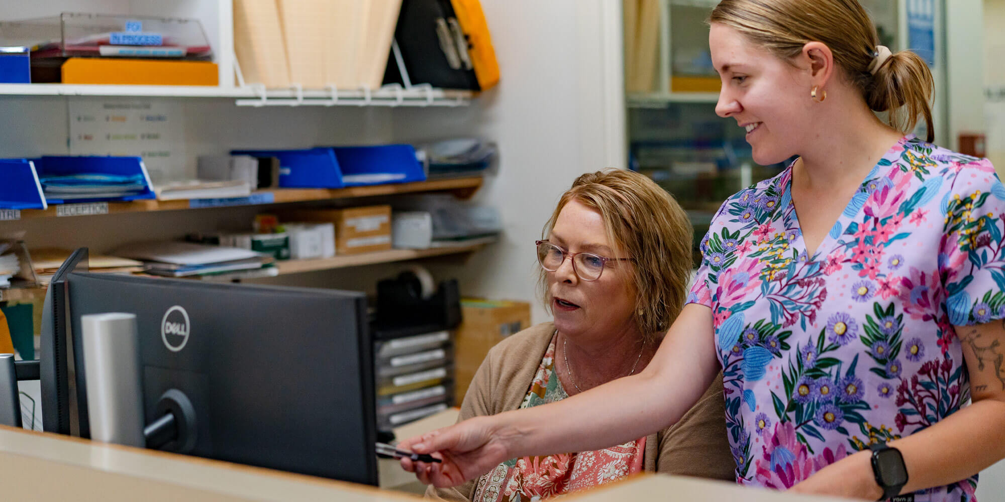 Nurse and admin staff working together in an office