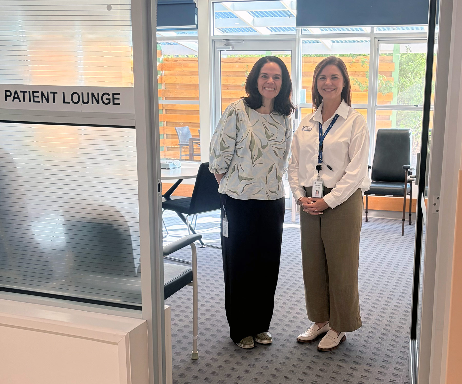 Two women at the announcement standing in the SGH lounge area